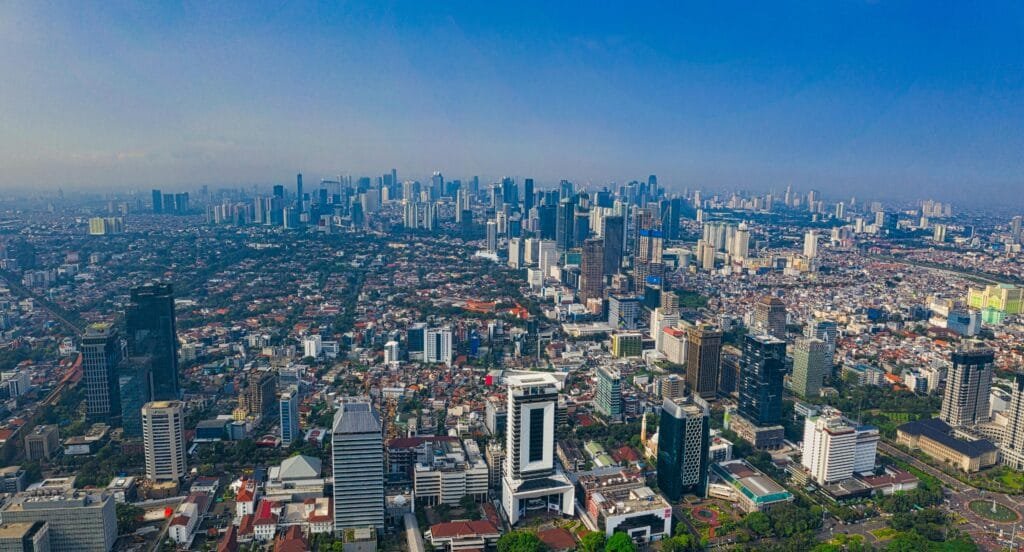 A high-angle shot showcasing the vibrant cityscape of Jakarta, Indonesia under clear skies.