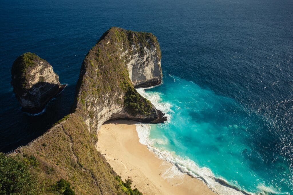 Stunning aerial view of the iconic Kelingking Beach in Bali, showcasing turquoise waters and dramatic cliffs.